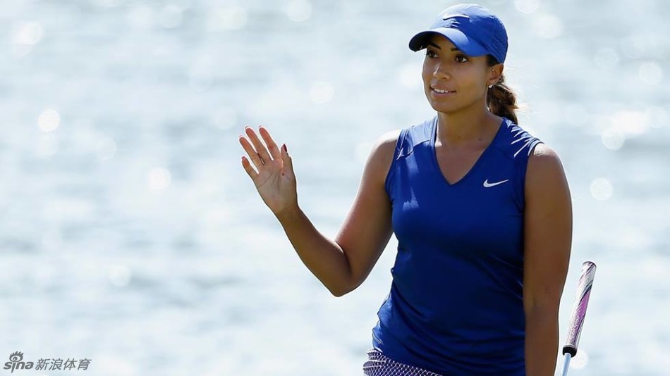 粉红豹克里默俯身观察果岭起伏，手指轻触草叶感受坡度，寻找最佳推击线路。