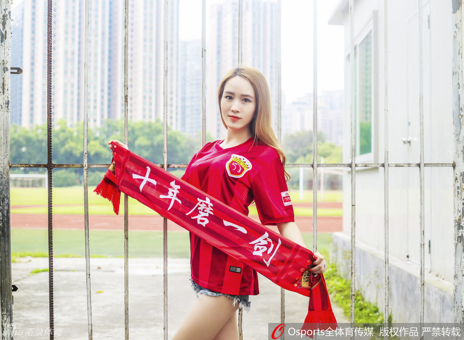 一位面容清秀的上海上港足球宝贝，在璀璨的夜色中深情高举着球队围巾，眼神中饱含着对主队胜利的热切期盼，红色的围巾如同燃烧的火焰。