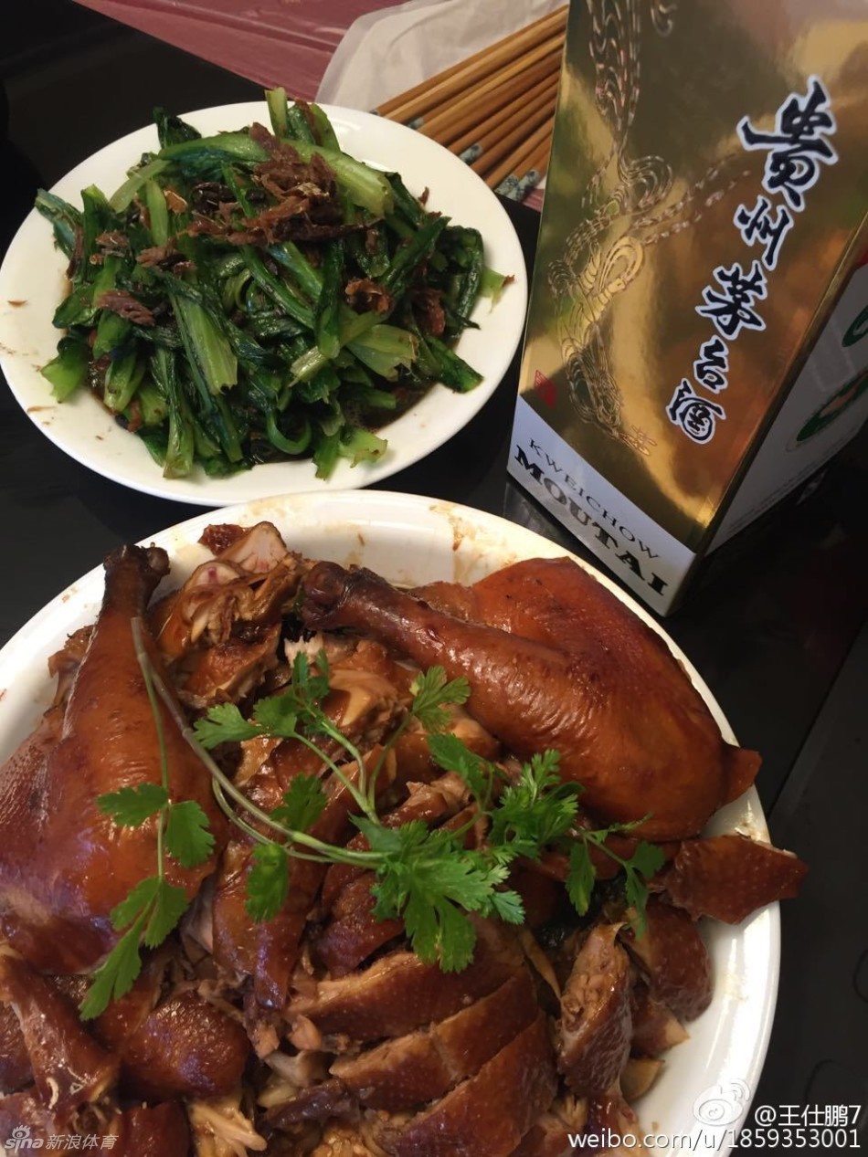 后厨案板上摆满切好的配菜和未下锅的鲜鱼，朋友在灶台前忙碌的身影，透露出为聚会精心烹制的用心