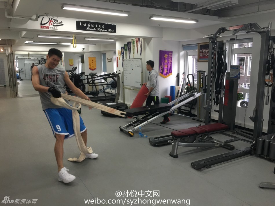 训练师正在仔细查看孙悦腿部肌肉的发力情况，孙悦紧咬牙关，额头渗出细密的汗珠，每一下抬腿都充满了力量感与挣扎，仿佛在与地心引力进行无声的抗争。