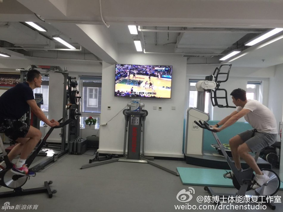 训练师的手轻轻触碰着孙悦的腿部，仔细感受肌肉的收缩频率，孙悦则全神贯注地完成着规定的动作，身体上连接的线路随着他的动作轻微晃动，仿佛是连接着他与赛场梦想的生命线。