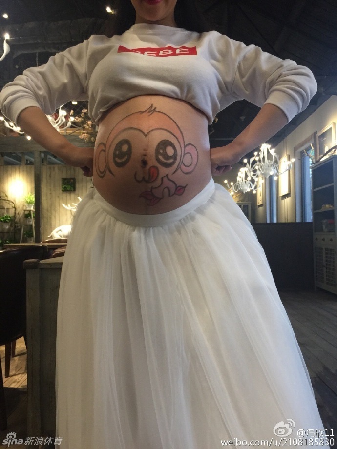 冯欣与爱妻甜蜜依偎，两人双手交叠轻放在彩绘孕肚上，仿佛在绘制一幅名为“未来”的美好画卷，幸福感油然而生。