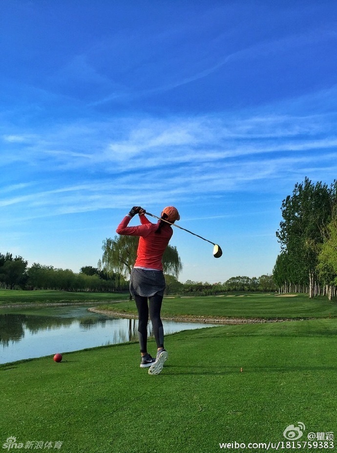 瞿颖在金色夕阳的球道上专注地调整握杆姿势，神情认真而放松。