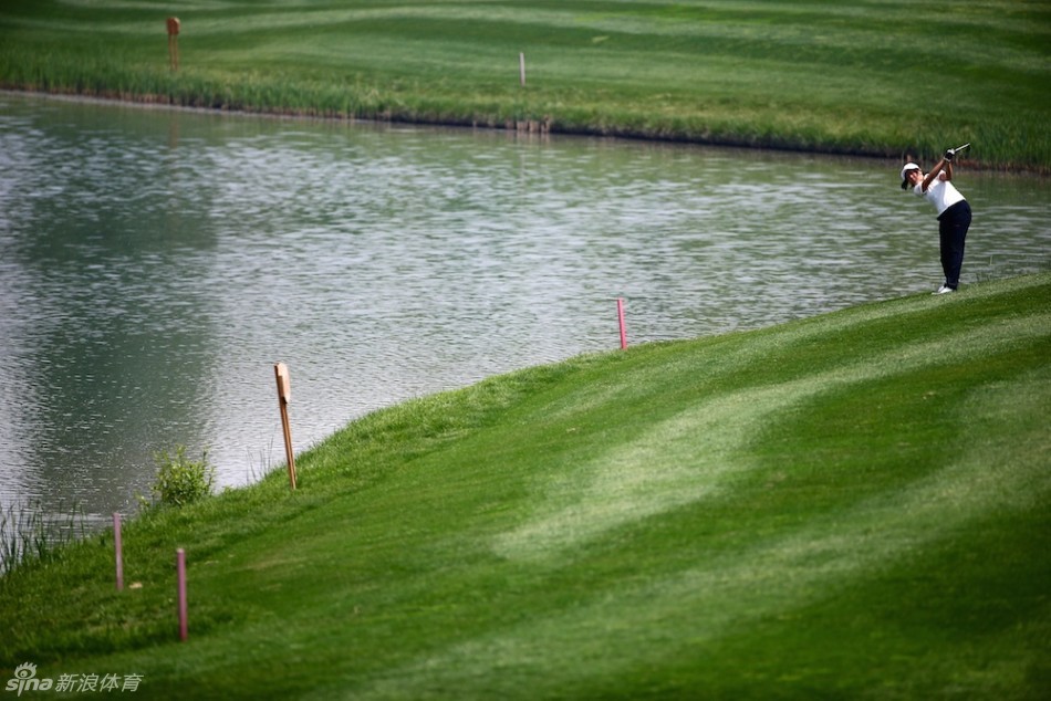 球员陈昊隆在比赛中俯身仔细阅读果岭起伏，研判推杆线路
