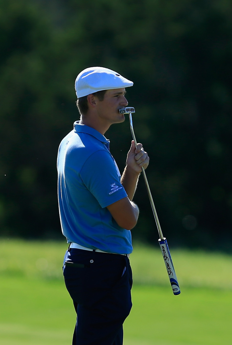 一名球员在沙坑中仔细考量救球方案，沙坑杆已就位，挑战与机遇并存。