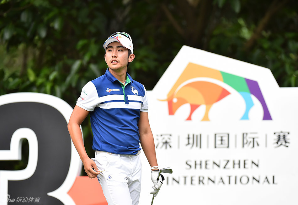 高尔夫球手在开球前凝神观察，远方是蜿蜒的球道与天际线