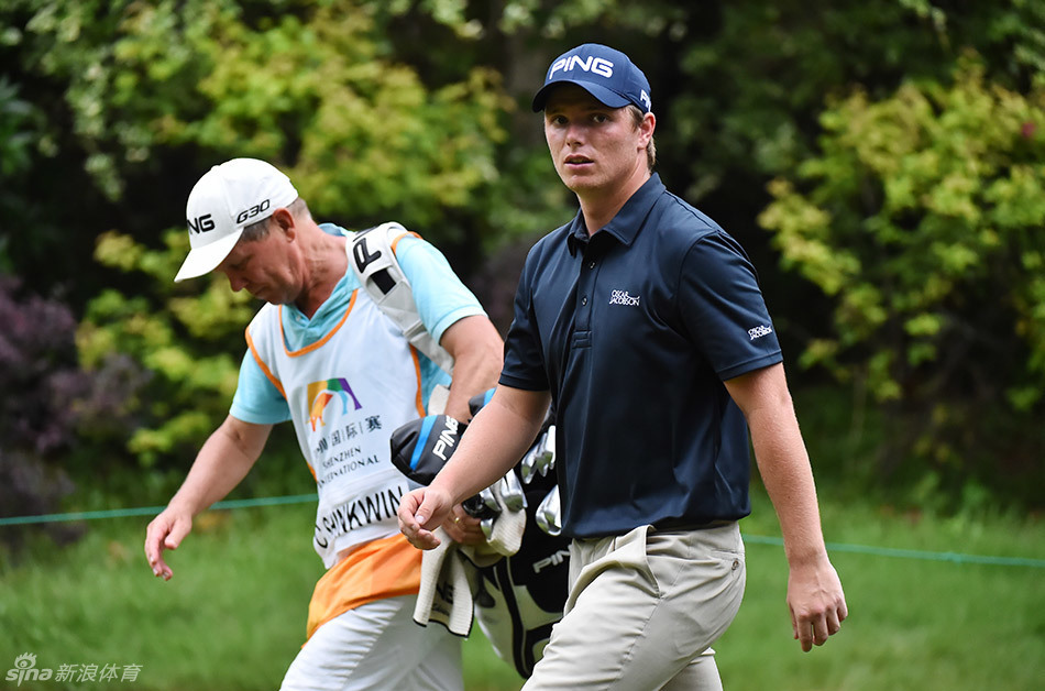 选手在果岭上俯身观察推杆线路，神情严肃而专注