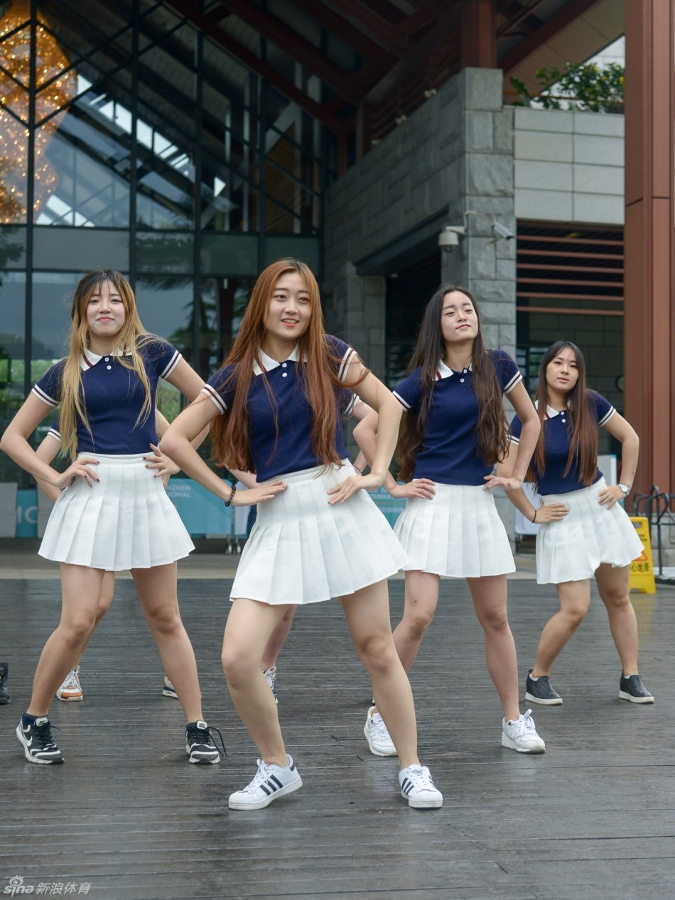 夕阳下，观众手持赛事纪念册满意而归，背景是沐浴在金色余晖中的赛场入口