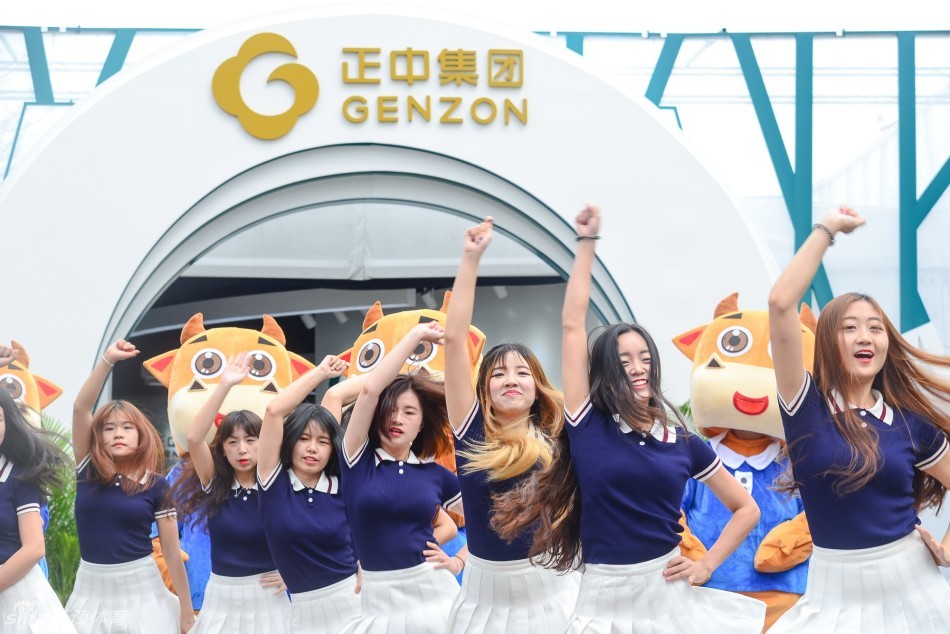 文化体验摊位上，小朋友正在志愿者指导下尝试趣味高尔夫推杆游戏