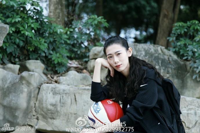 午后的阳光下，她身穿休闲装坐在球场边，回眸一笑，青春的气息与运动的背景完美融合，仿佛漫画中走出的学姐