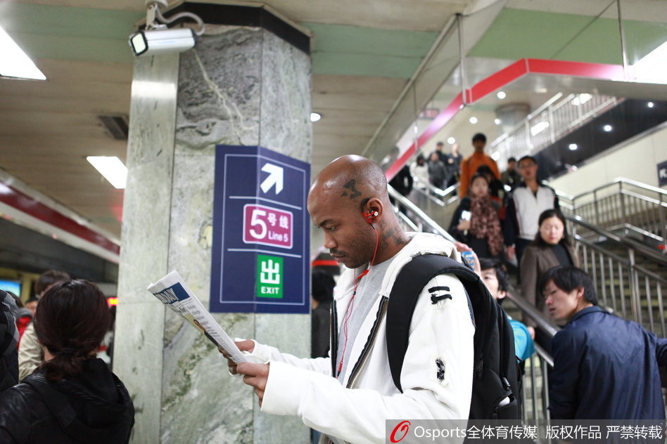 相声剧场里，马布里身穿大褂与相声演员曹云金同台，他手持折扇表情认真，而曹云金则在一旁做出夸张的逗哏表情，台下观众笑声一片