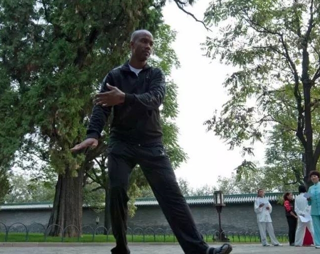 绿树掩映的公园里，这位外国友人正神情专注地打着太极，一招一式间透着一股认真劲儿