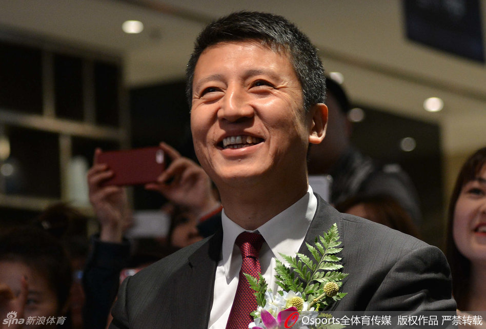 郭士强在球迷活动中开怀大笑，眼睛眯成了一条缝，他双手拿着一个蓝色的球迷留言本，似乎被本子上的内容逗得前仰后合