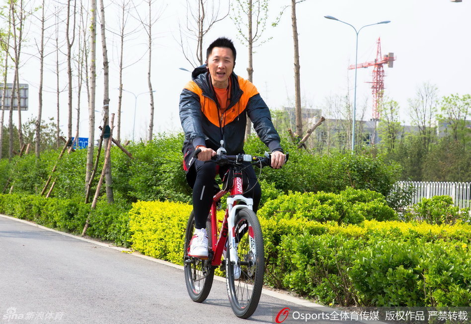 主教练许晋哲在场边双手抱胸，目光如炬地注视着场内队员们的每一次跑动和投篮，神情专注而严肃。