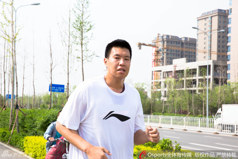 队长张学文在快攻中腾空而起，尽管汗水已打湿他的球衣，但他的眼神依旧坚毅，奋力将球送向篮筐。