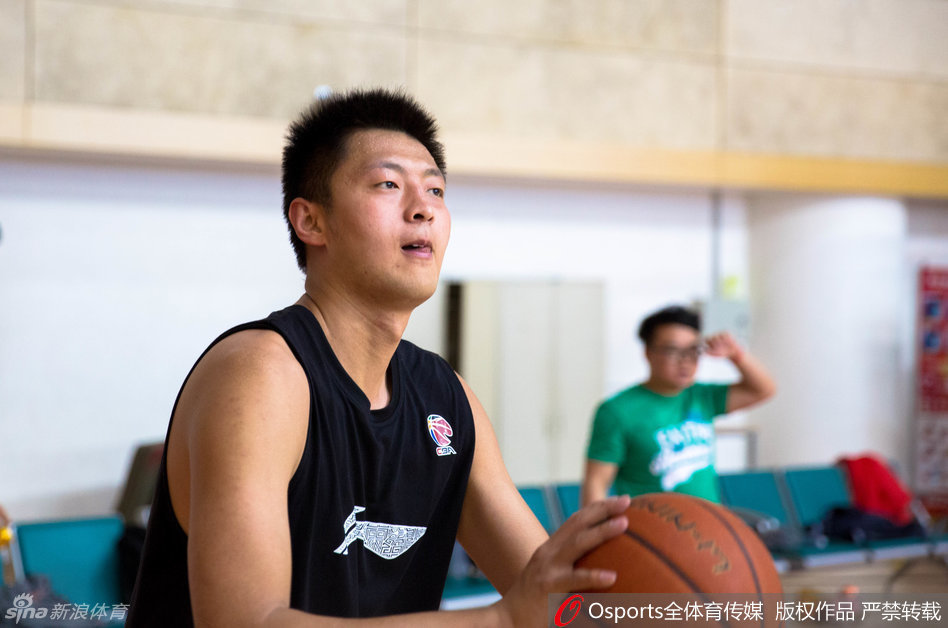 内线球员葛昭宝和邢志强在篮下进行攻防对抗，两人肌肉紧绷，全力争抢位置，汗水在灯光下闪闪发光。