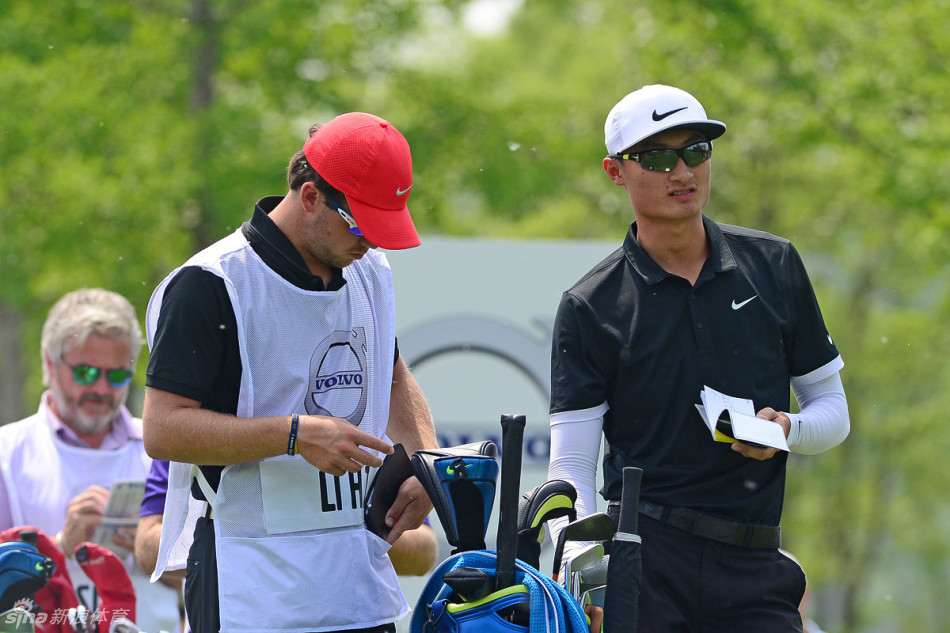 李昊桐在果岭上观察推杆线路，他微微屈膝，目光如炬，仔细审视草地的每一个起伏