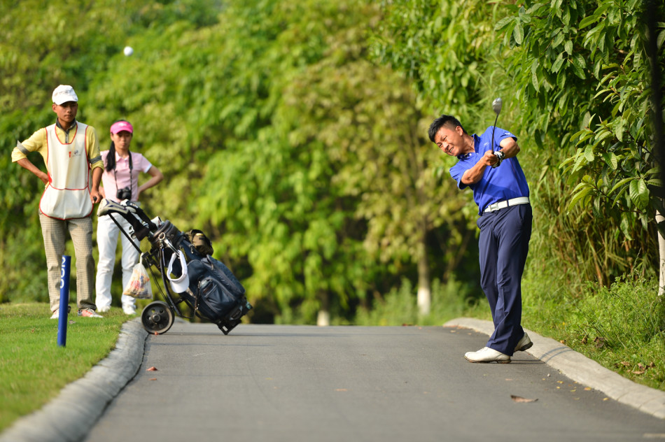 冠军球队成员高举奖杯庆祝胜利，背后是重庆保利球场美丽的夕阳与绿地