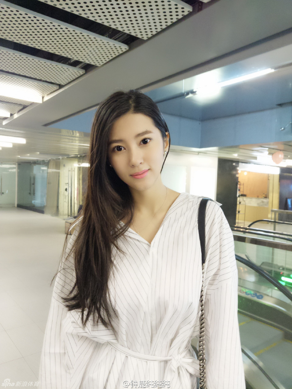 夕阳的余晖染红了天际，钟鹿纯背对镜头站在海水中，回眸的瞬间被抓拍，画面充满了电影般的质感，宁静而美好。