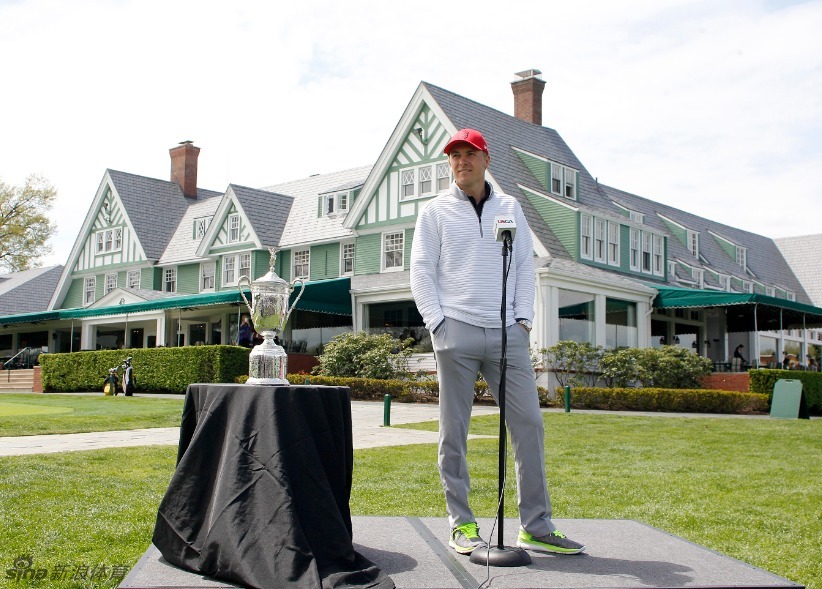 斯皮思背对镜头走向下一个挑战，球包上的标志在阳光下熠熠生辉