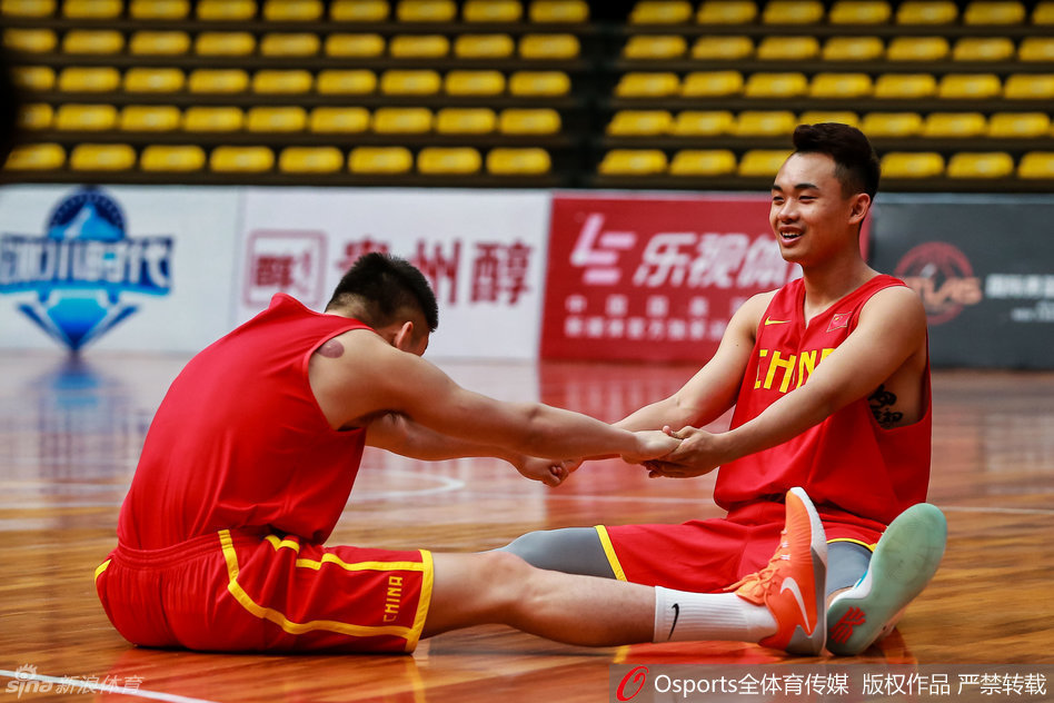 射手原帅正在队友的协助下进行上肢与躯干的拉伸，表情轻松，队友之间配合默契。