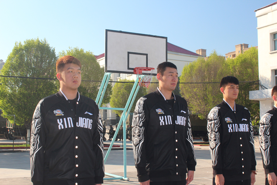 营房内，西热力江全神贯注地按压着手中的军被，原本蓬松的被子在他一遍遍的修整下，逐渐显露出标准的棱角。李秋平指导也亲自上阵清洗器具，以身作则展现了教练组的严谨作风。