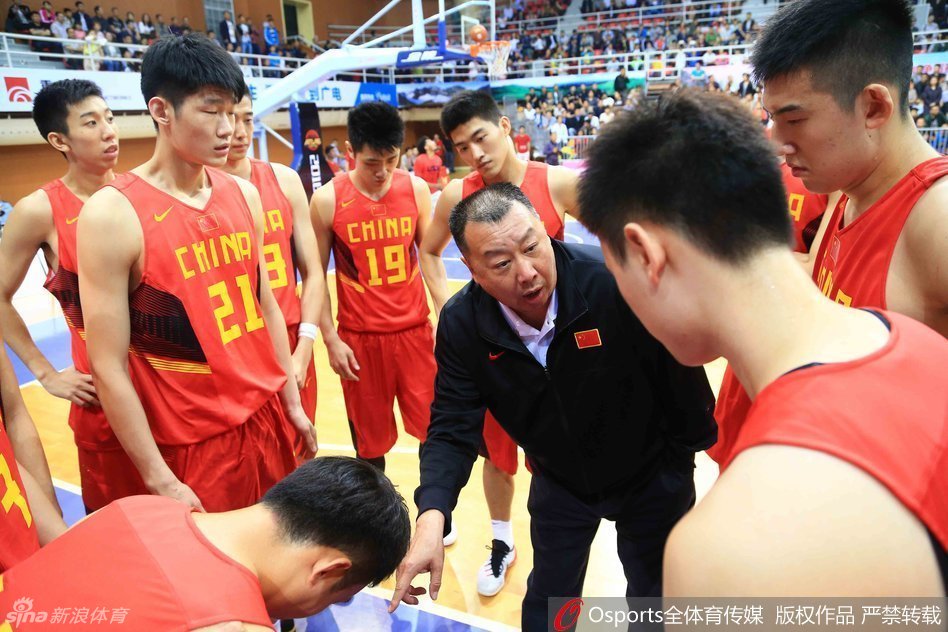 主教练吴庆龙手持战术板神情严肃地布置战术，手臂挥舞间仿佛要将毕生绝学传授给场上的弟子们。