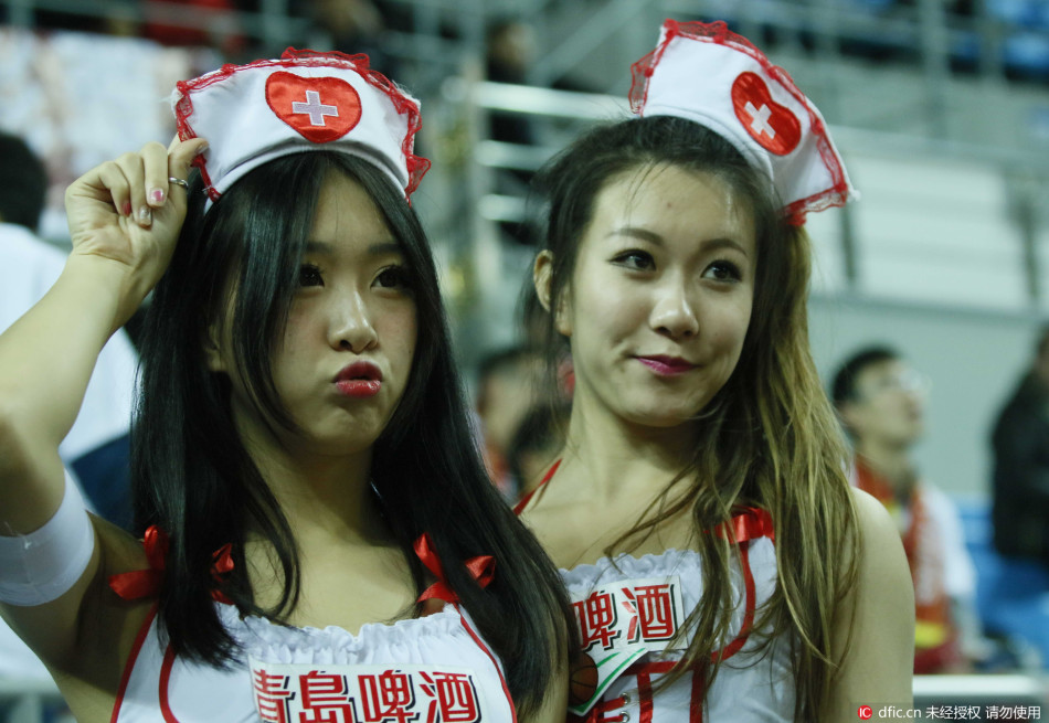 一位穿着粉色护士服的姑娘在赛场边，脸上带着温暖的笑容，手中紧握着急救用品