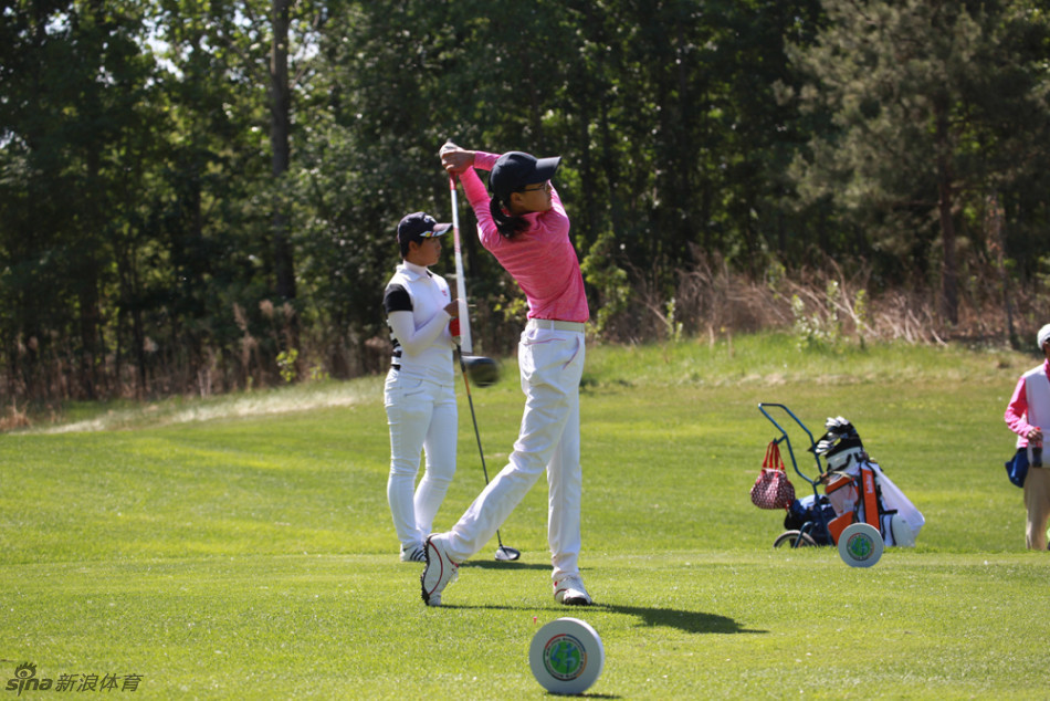 少女球手侧身优雅挥杆,身姿灵动,与广阔草地构成一幅和谐动人的运动画卷