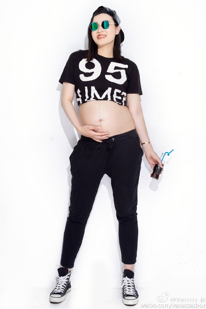 王然迪在沙发上摆出俏皮的表情，尽管孕期身体浮肿，但她依然用自信的姿态诠释着别样的性感与美丽。