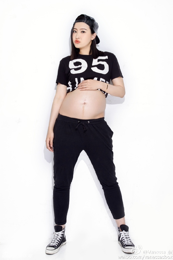 换上黑色修身长裙的王然迪，展现出孕期女性的优雅曲线，对着镜子拍下这张时尚感十足的孕期纪念照。