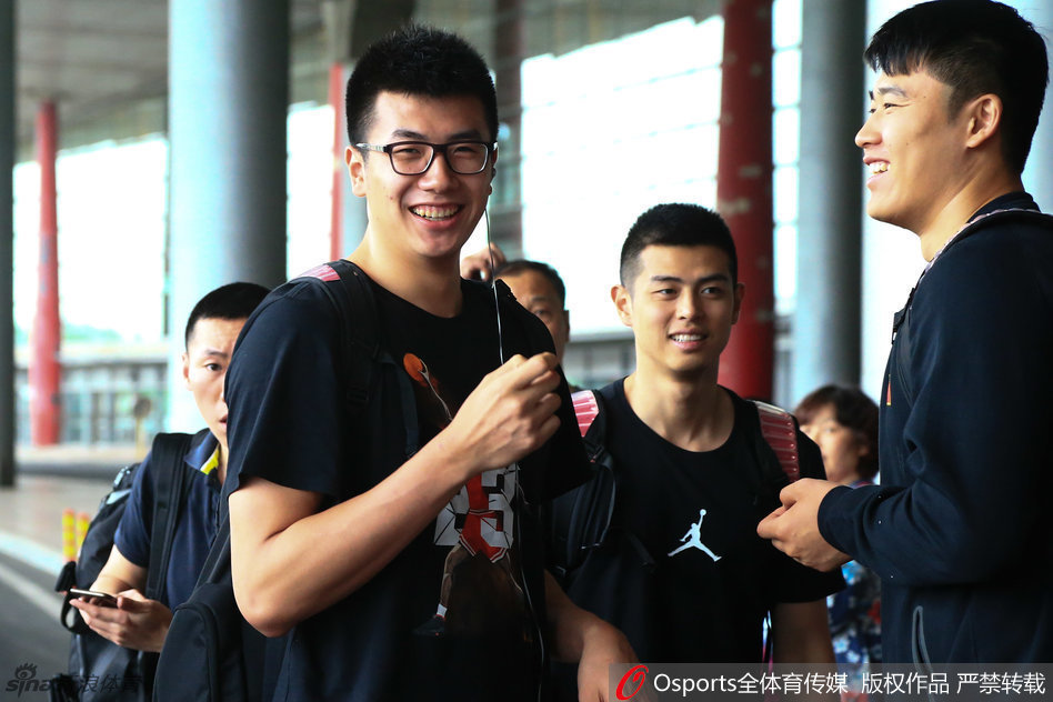 锋线尖刀李根现身机场，面对接机人群露出轻松笑容，身背行囊步伐矫健，仿佛对即将到来的恶战早已胸有成竹。