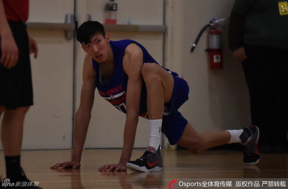 在正式开始严苛的体测之前，周琦神情专注地进行着热身活动，拉伸筋骨，为即将到来的挑战做好万全准备。