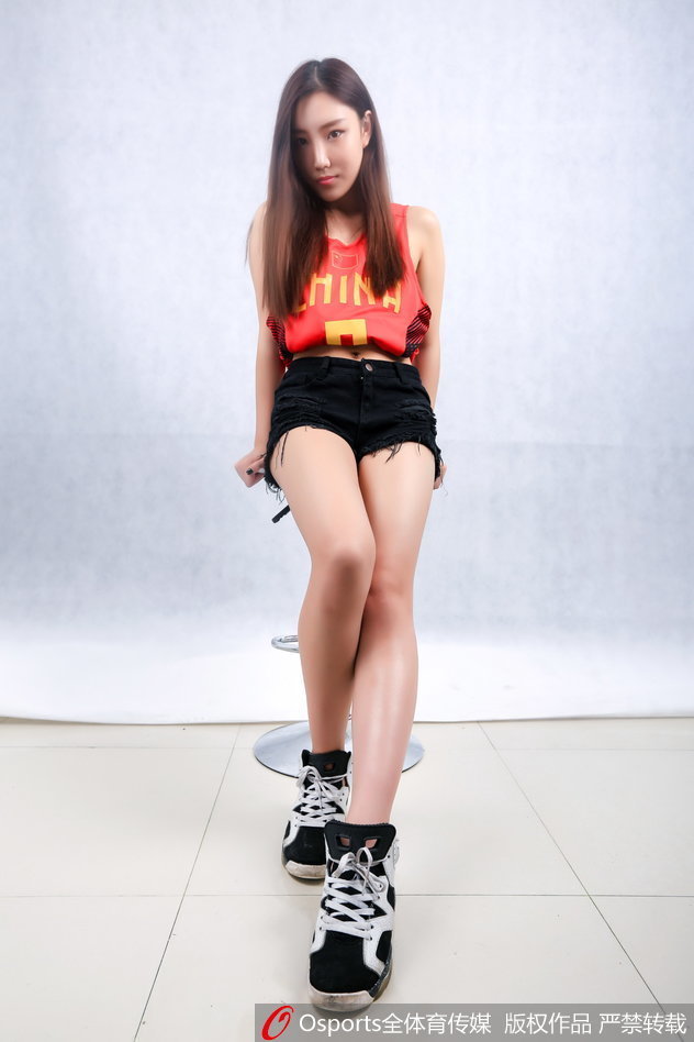 一位篮球宝贝侧身微笑，清秀的面庞在光影下显得格外动人，乌黑的长发自然披散，流露出邻家女孩般的温婉气质。