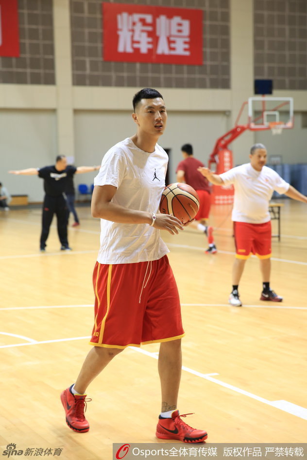 训练场上群像生辉，中国男篮的小伙子们正在助理教练的指导下进行战术演练，窗外的阳光洒在地板上，映照着他们为奥运梦想而战的身影。