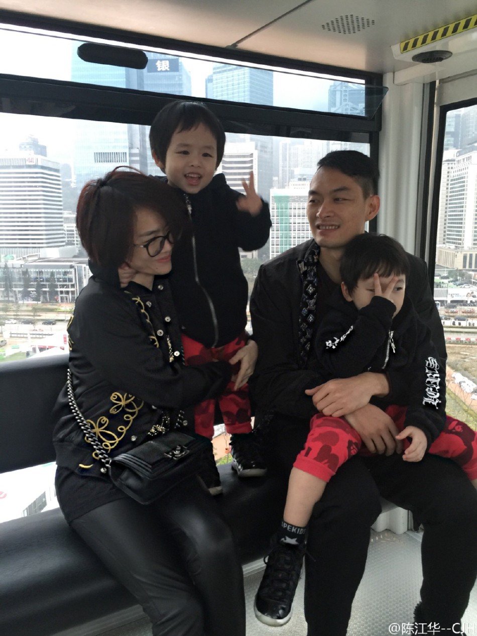 陈江华与双胞胎儿子在客厅的地毯上专心致志地组装玩具，地上散落着色彩缤纷的积木，父子三人神情专注，画面既温馨又充满童趣。