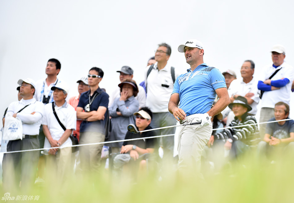 谷原秀人与他的中学同学兼球童在比赛中并肩前行，两人专注地讨论下一杆的策略，展现赛场上的信任与默契。