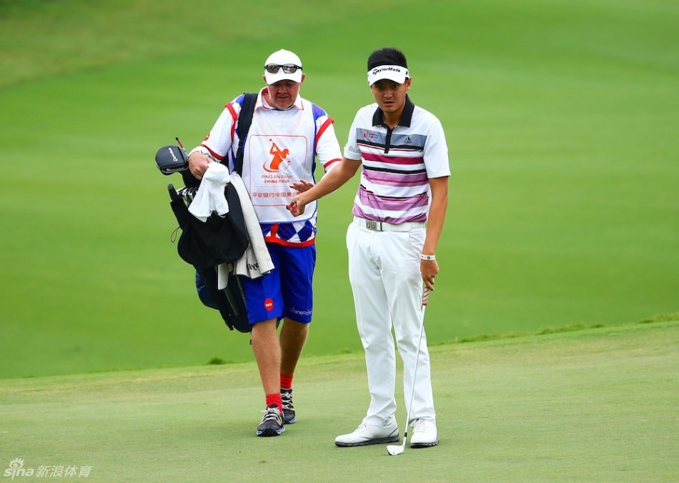 刘晏伟与他的球童一同前行,两人正在交流,是赛场上不可或缺的伙伴