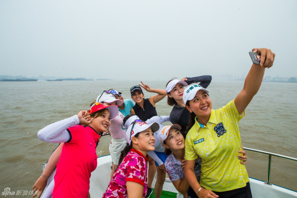 球员与嘉宾在游艇上迎着江风欢乐自拍，背景是浩瀚长江与雄伟的苏通大桥