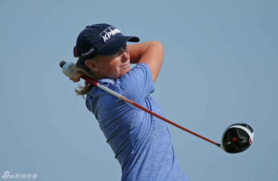 球员萨拉·珍·史密斯在果岭边沙坑中奋力救球，沙砾飞扬，展现高超的短杆技术。