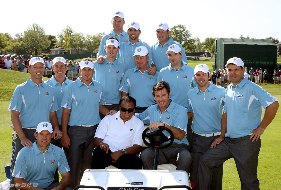 米克尔森弯腰与坐在椅子上的阿里握手致意，表情恭敬而温暖，展现跨代体育精神的传承