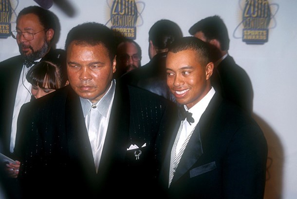 阿里与年轻的老虎·伍兹亲切握手，两代体坛巨星的双手紧握，笑容灿烂如阳光穿透云层