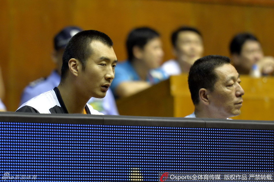 薛玉洋神情专注地坐在场边，目光紧盯着场上外援的激烈对抗，仿佛在思考如果自己登场该如何应对。