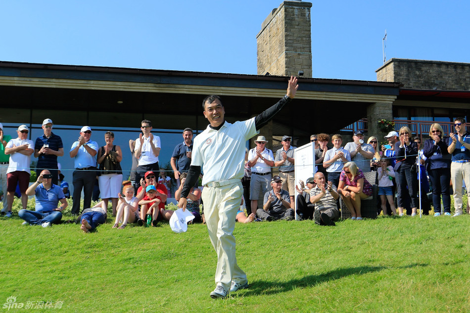 张连伟夺冠后向全场观众挥手致意，分享胜利喜悦，身后是威尔士的美丽赛场