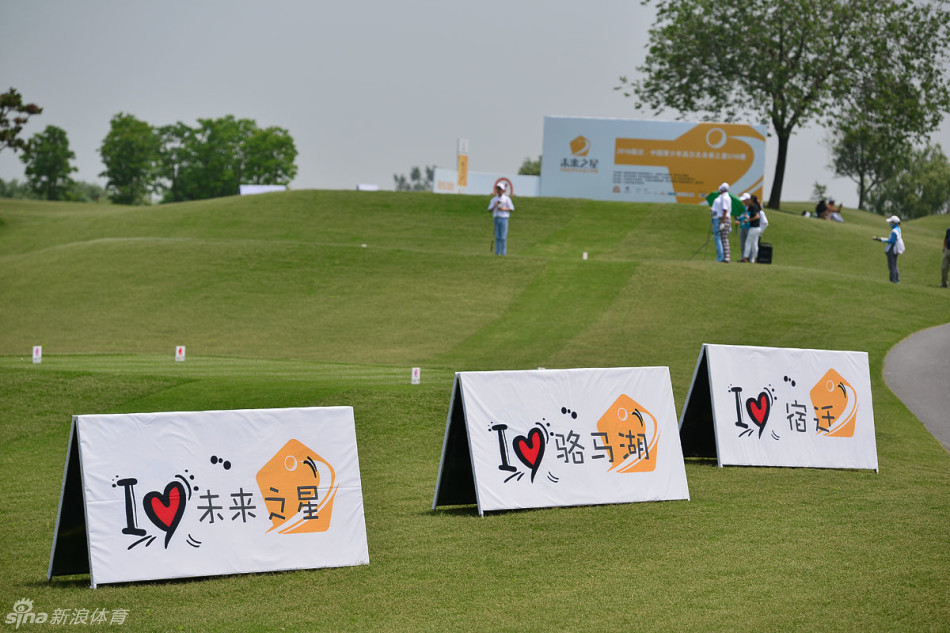 颁奖仪式上，一群年轻的高尔夫球手们手持奖杯与奖品，开心地合影留念，他们笑容灿烂，展现了运动带来的快乐与友谊，身后是绿意盎然的球场。