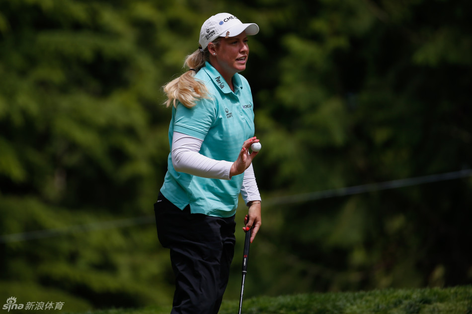 高宝璟与球童在果岭边专注商讨下一杆策略，表情沉着自信