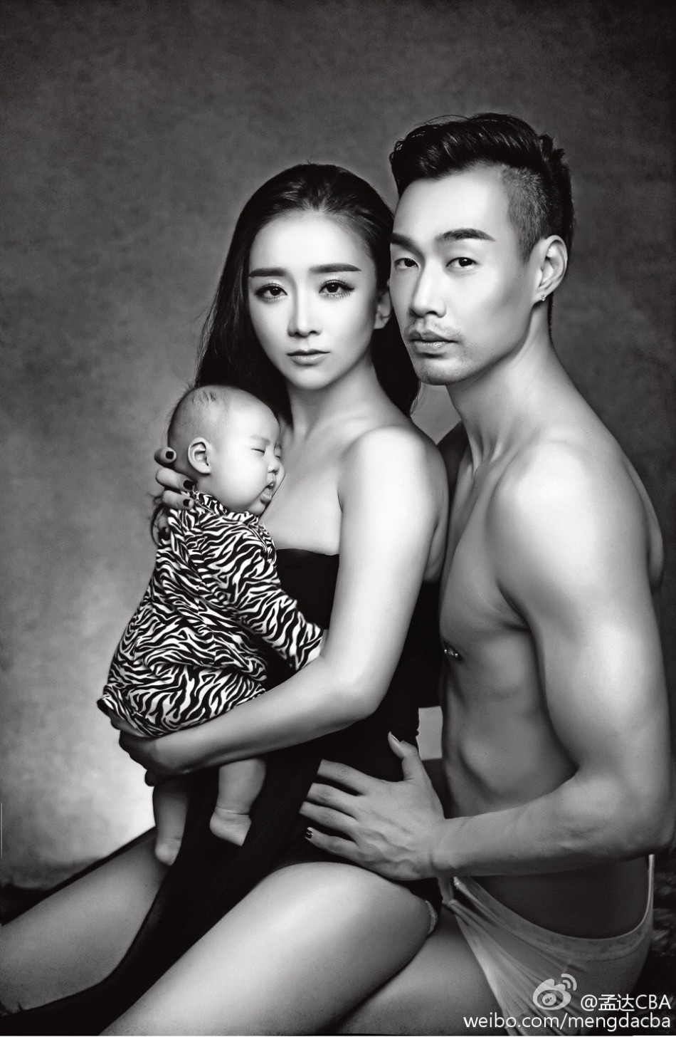 妈妈身穿休闲装展现迷人曲线，抱着孩子眺望远方，画面充满温馨的母爱与时尚韵味