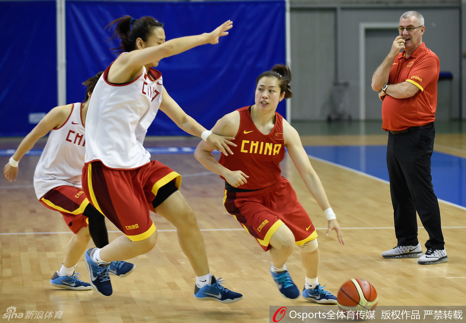 队员们迅速围绕在主帅马赫身边，孙梦然、邵婷等主力队员俯身倾听，马赫则弯着腰用手势比划着刚刚训练中出现的问题，要求大家立即改进。