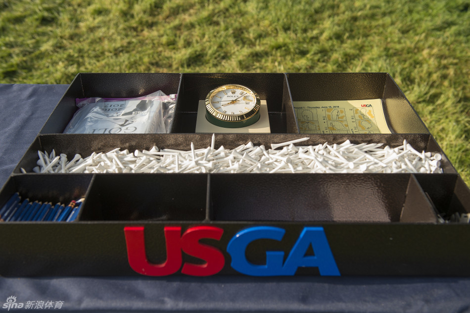 达斯汀·约翰逊在第十八洞果岭举起冠军奖杯瞬间，喜悦与释然交织，背景是见证无数历史的奥克芒俱乐部会所。