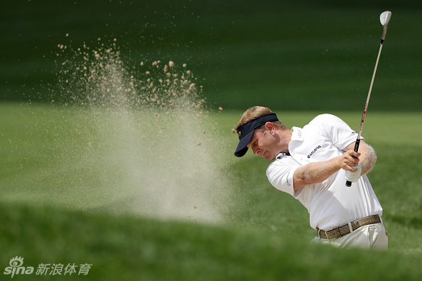 绿草如茵的球场在阳光下延伸,远处树木与水面构成和谐景观,展现高尔夫运动与自然环境浑然天成的静谧之美。